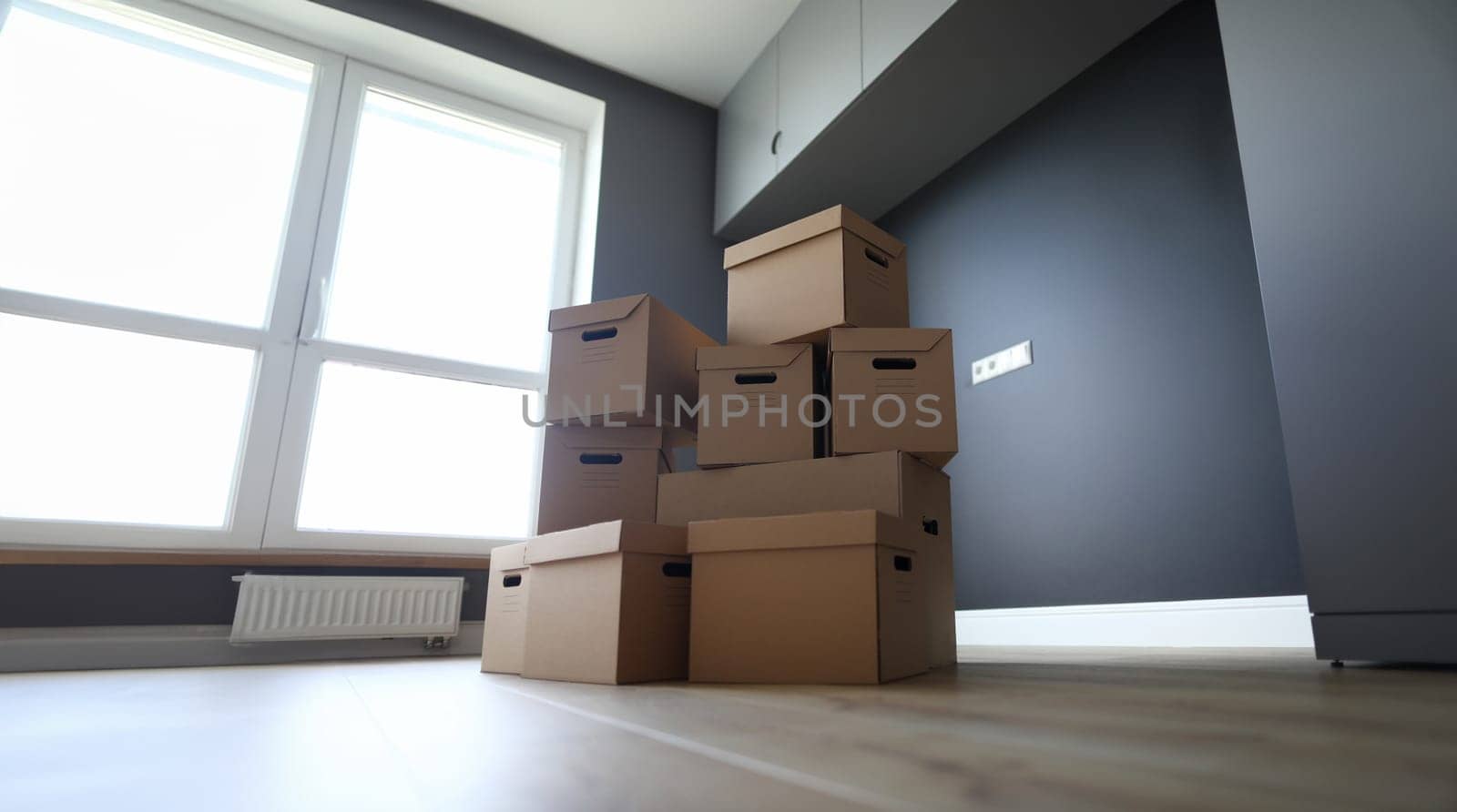 Lot of cardboard boxes on wooden floor new flat closeup by kuprevich