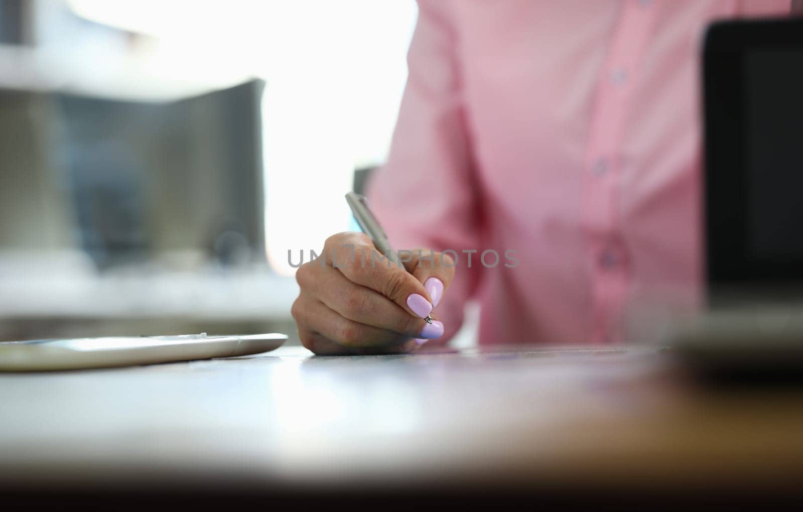 Close-up on table female hands take notes with pen. Remote work from home during quarantine. Lack office work. Downtime due to force majeure situations. Crisis in economy, job search remotely