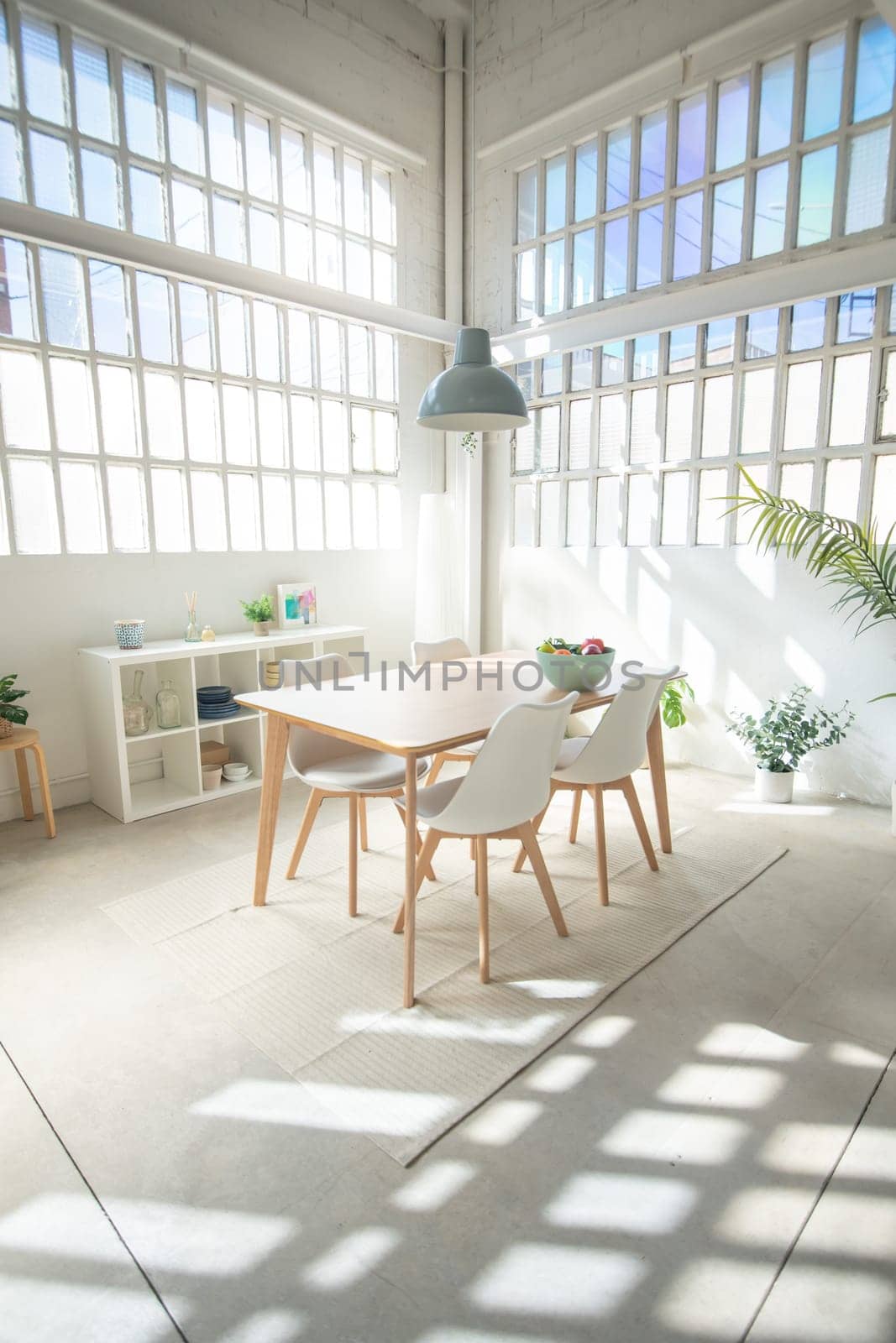 Interior design industrial loft with table, and chairs in a dining room. Sun trough the window. by PaulCarr
