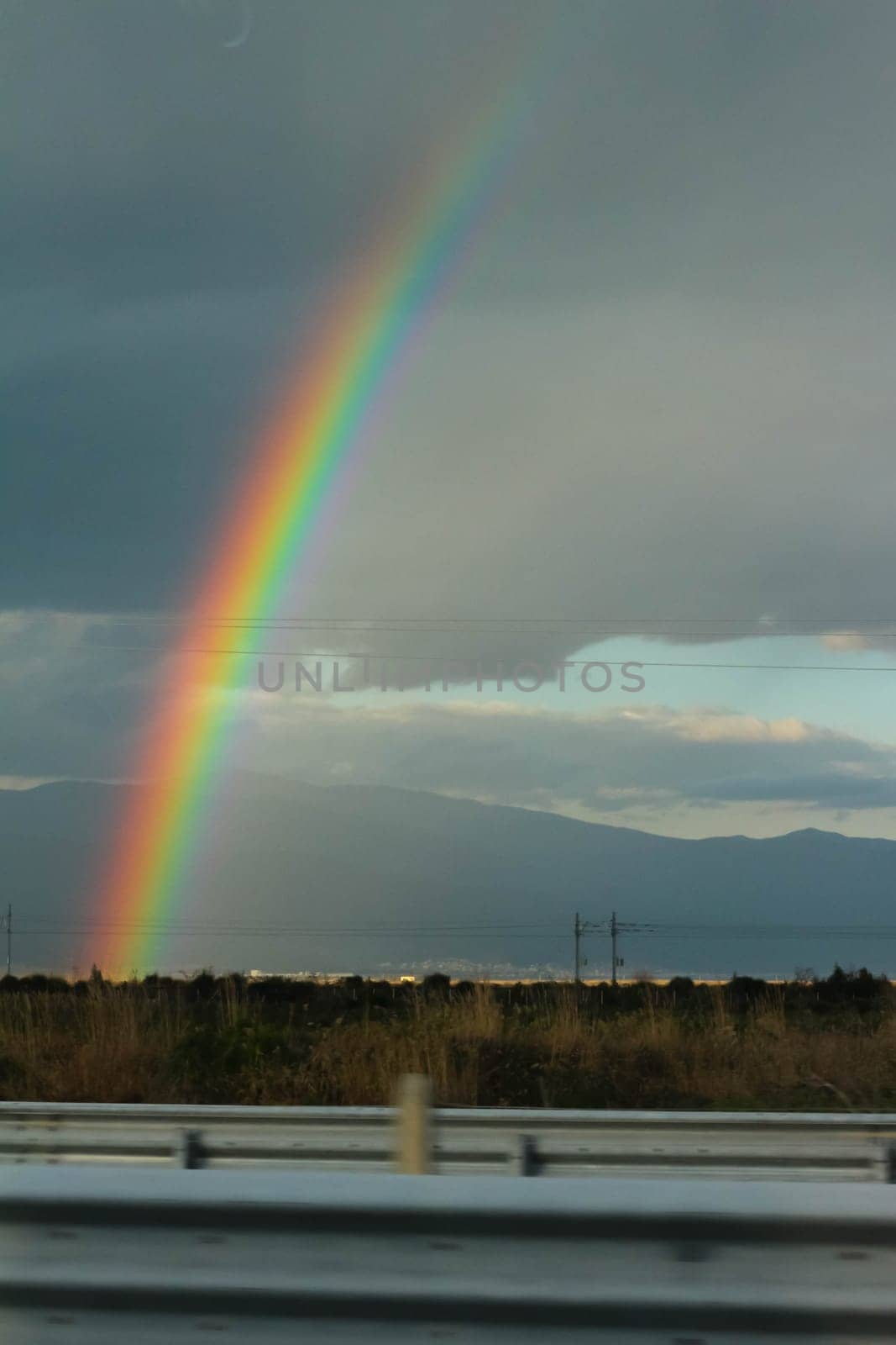 Embark on a visual journey as you capture the stunning beauty of a rainbow set against a backdrop of dramatic clouds