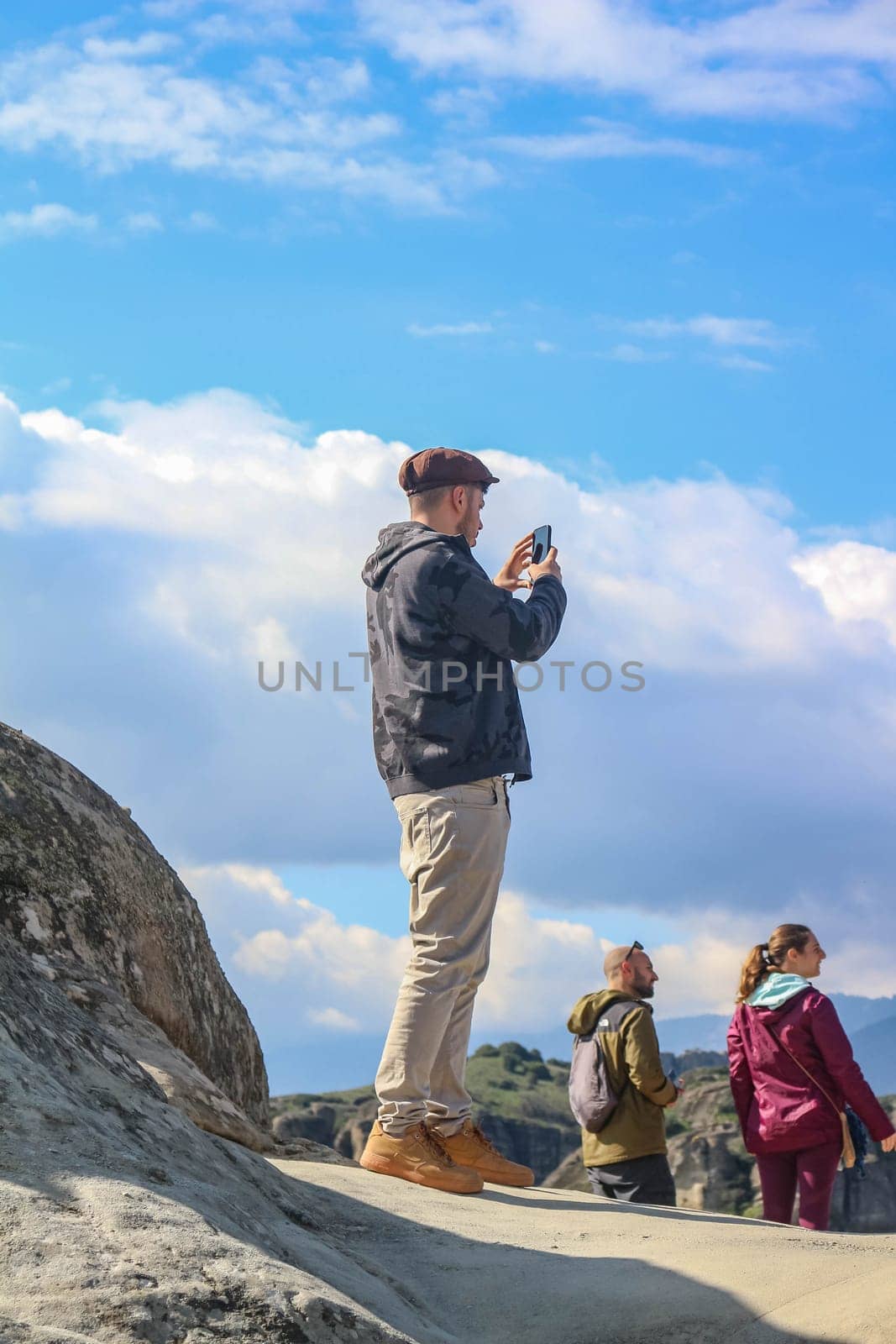 Gazing Into the Abyss: Tourist Enjoying the Cliff Views of Meteora, Greece by DakotaBOldeman