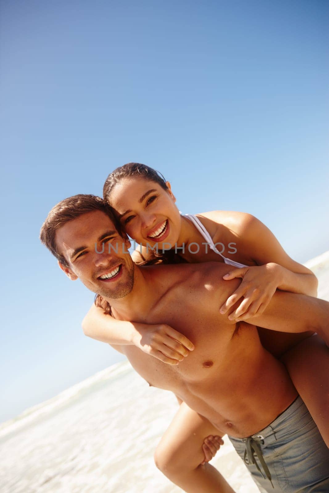 Vacation, portrait and couple piggy back at the beach with love, hug and support together on holiday in summer. Laugh, sea and happy with smile and bonding by water with travel in Miami with people.