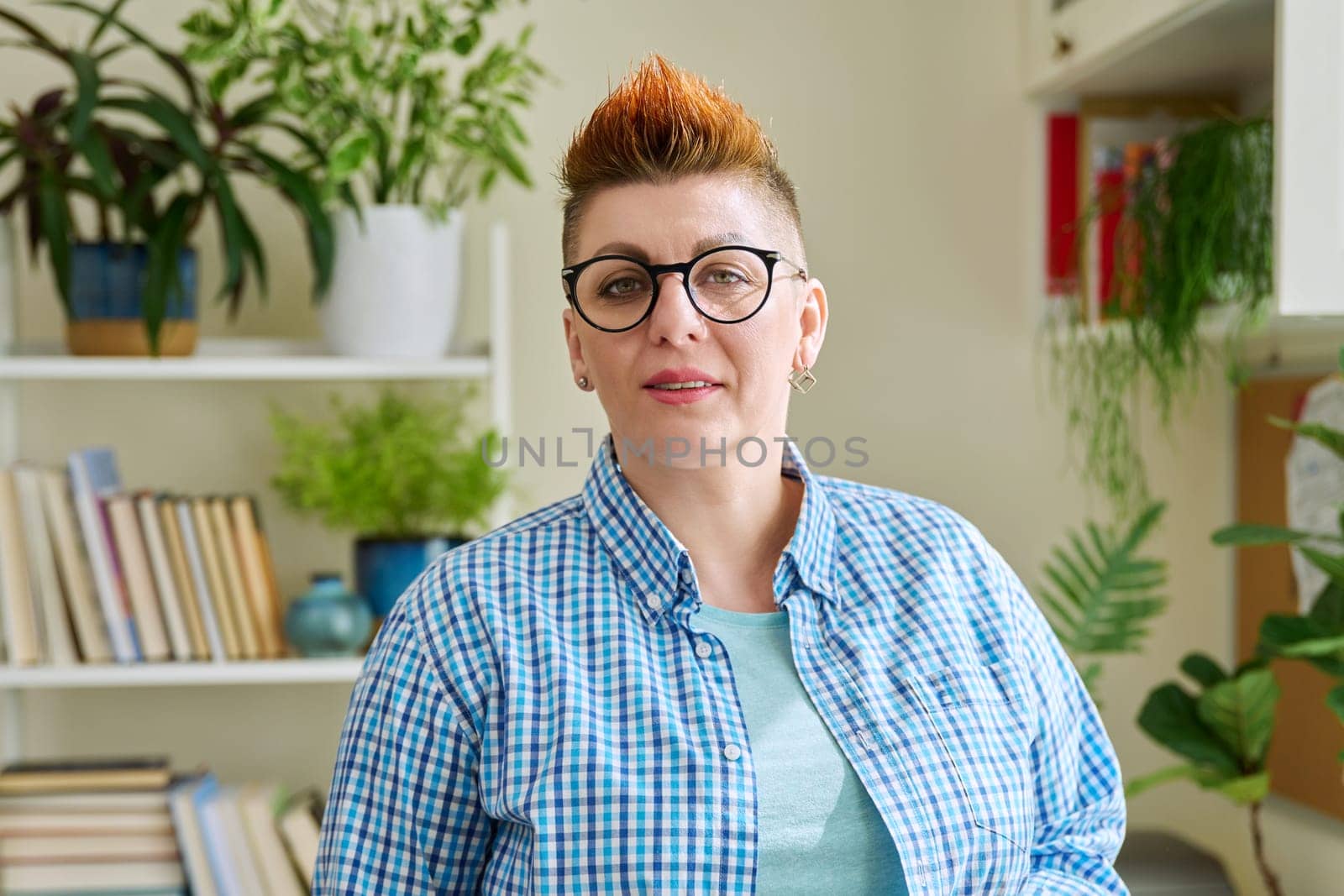 Portrait of smiling middle-aged woman in glasses with red haircut by VH-studio