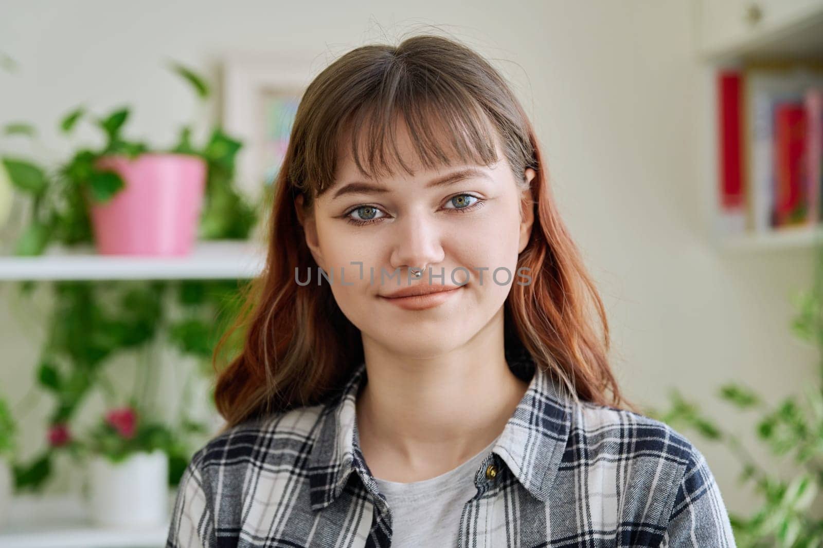 Portrait of smiling female teenager looking at camera in home by VH-studio