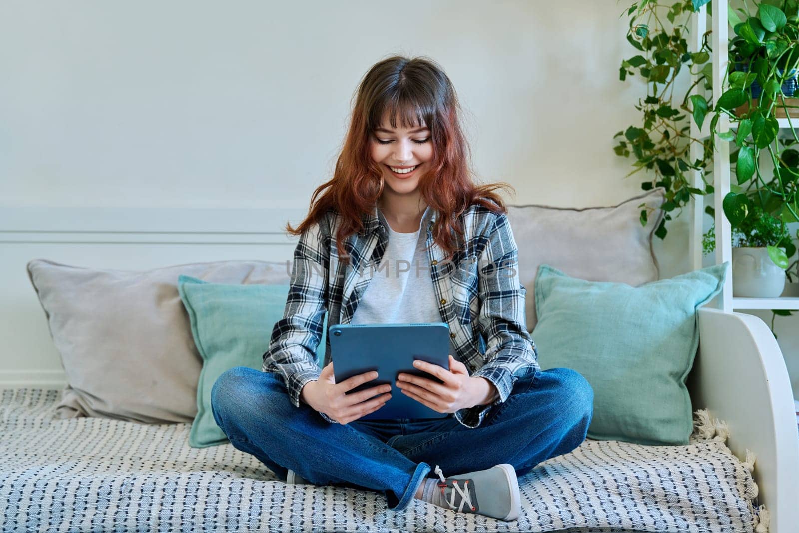 Young trendy girl using digital tablet for studying communication leisure by VH-studio