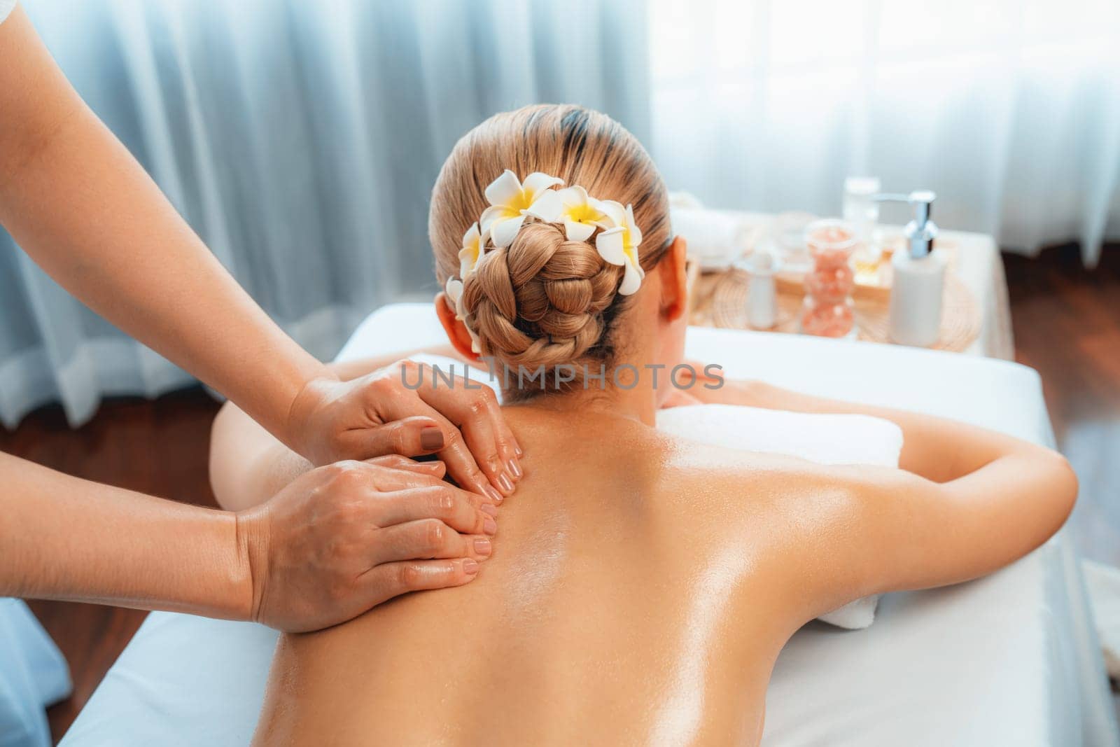 Caucasian woman customer enjoying relaxing anti-stress spa massage and pampering with beauty skin recreation leisure in day light ambient salon spa at luxury resort or hotel. Quiescent