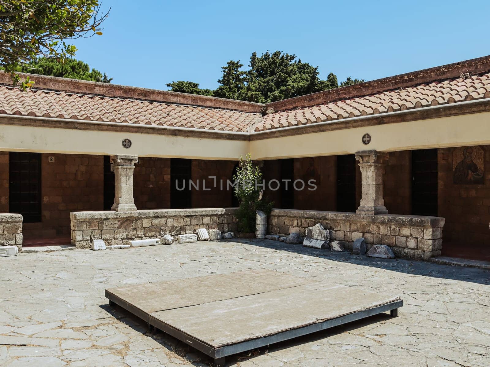 Beautiful view of the inner courtyard of the temple of the Virgin with architectural stones from the temple of Zeus on Mount Filerimos in Greece on the island of Rhodes, close-up side view. The concept of historical buildings.