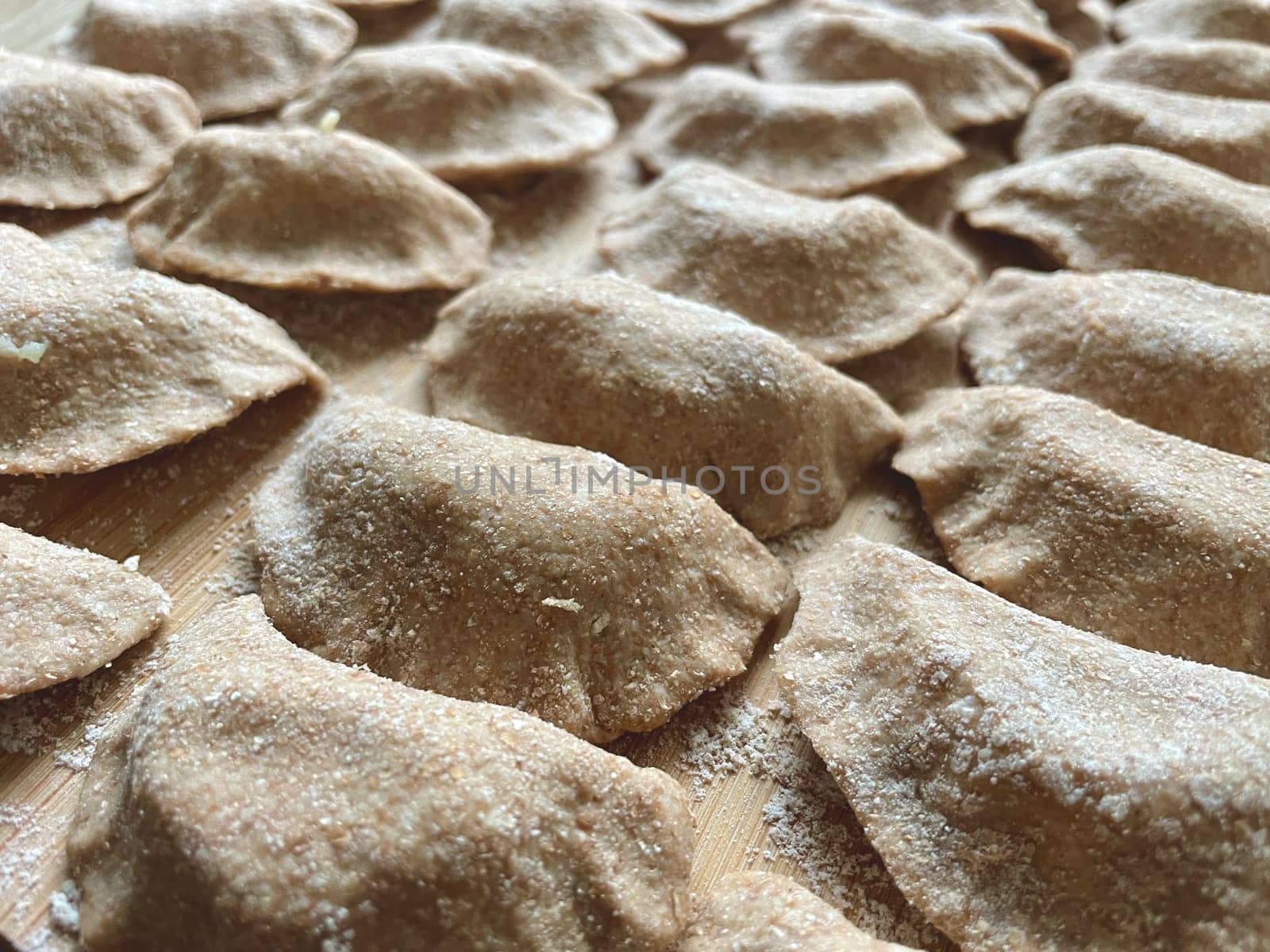 Dumplings made of whole wheat flour are molded on the kitchen board. High quality photo