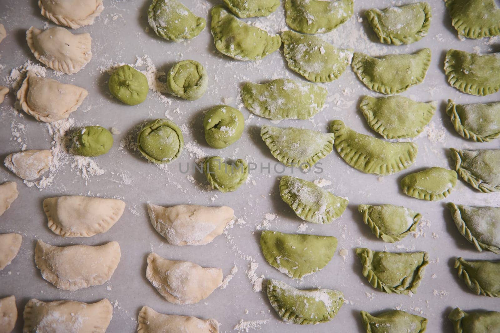 View from above. Food background with molded raw dumplings. Varennyky and ravioli on a floured marble surface of kitchen table. Ukrainian traditional cuisine. Food. Traditions and culture