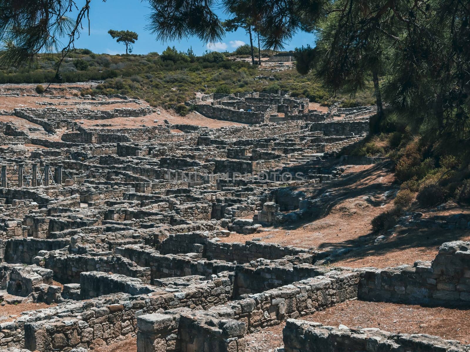 Beautiful panoramic view of the ruins of the historical ancient city of old Kamiros in the vicinity of the Zhiloko complex on the top of a mountain in Greece on the island of Rhodes on a summer sunny day, close-up side view.