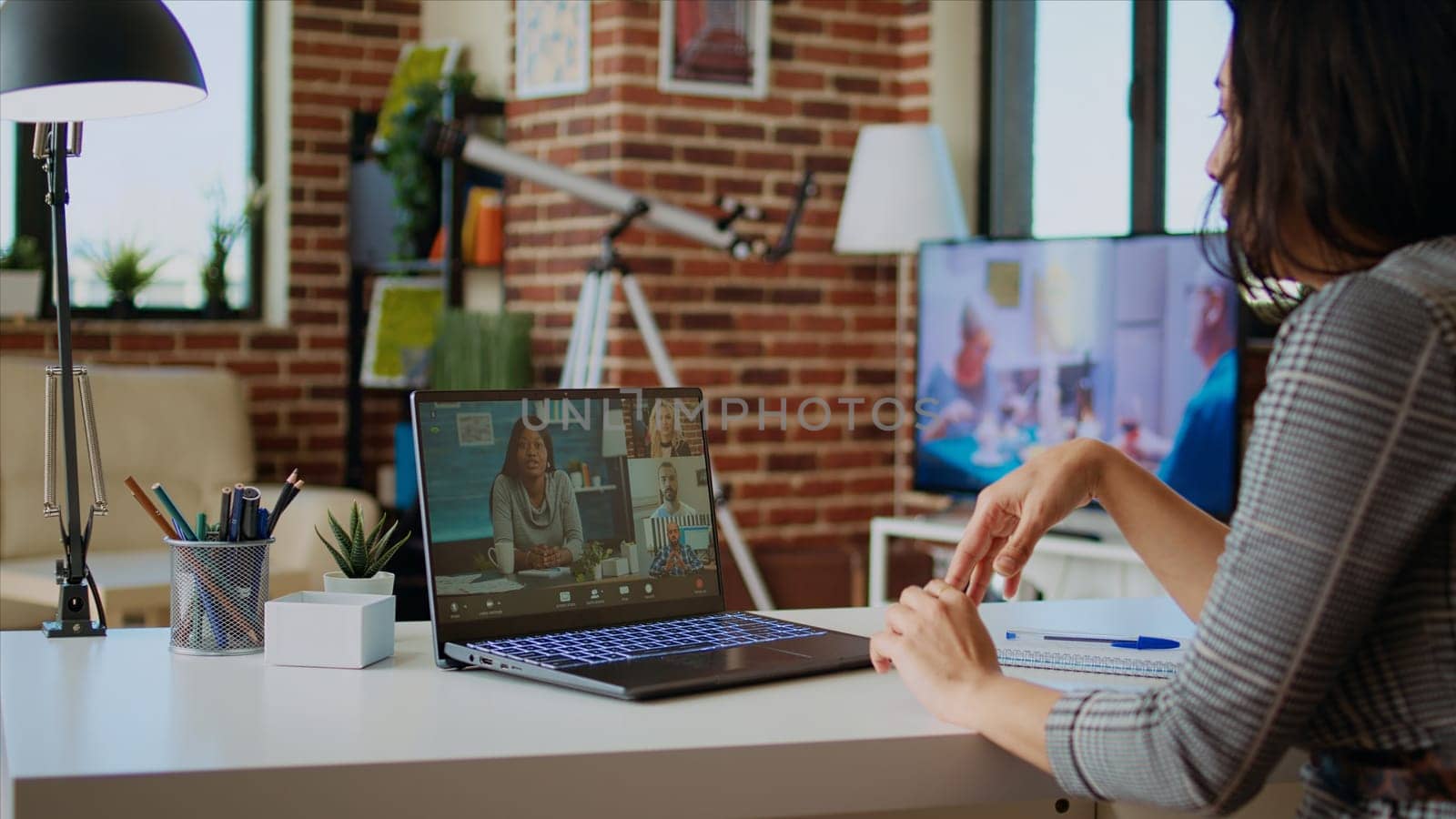 Remote professional holding q and a session with webinar participants via videoconference meeting in cozy apartment. Online videocall host engaging in online discussions with trainees, camera A