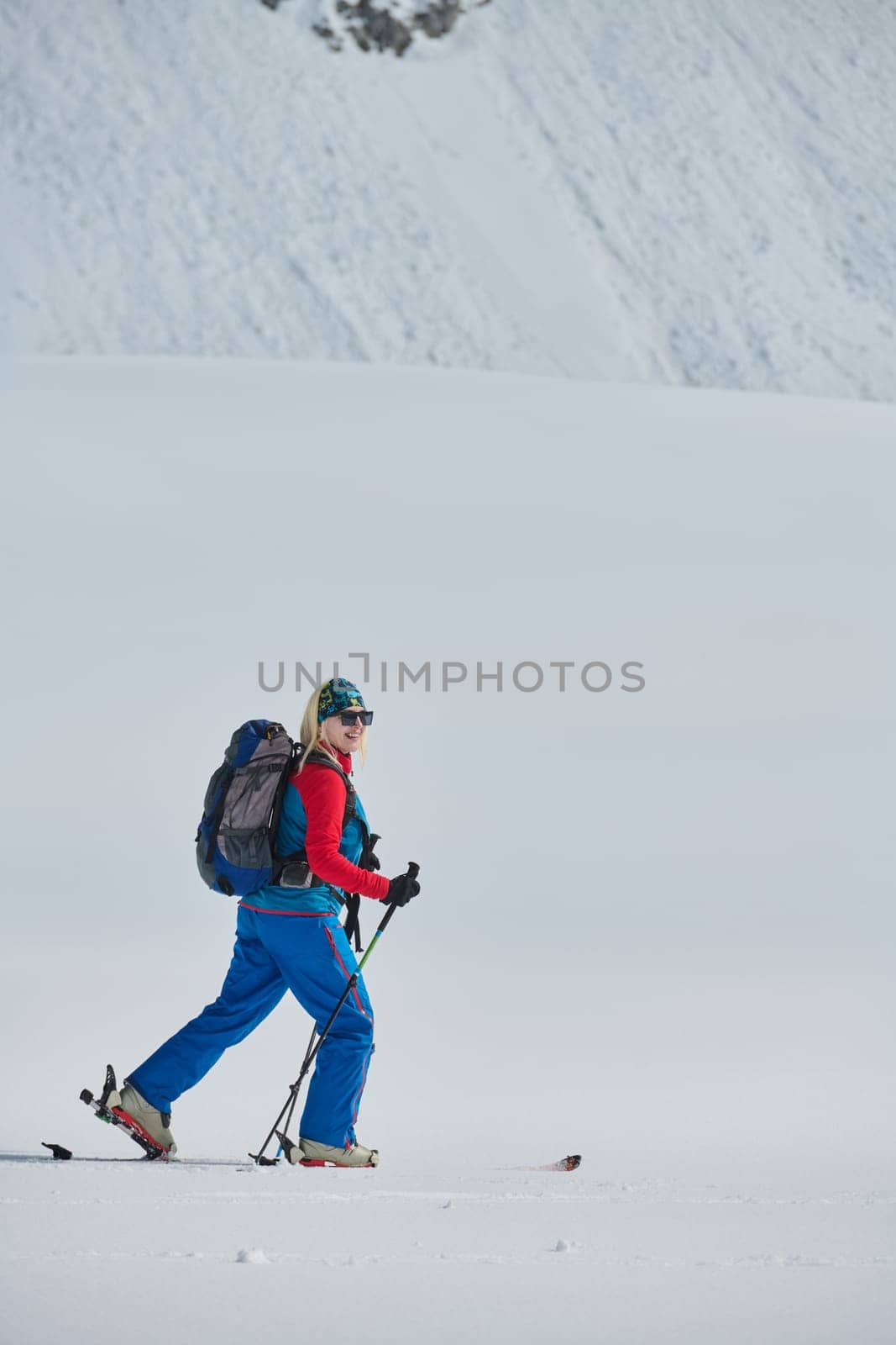 A Female Mountaineer Ascends the Alps with Backcountry Gear by dotshock