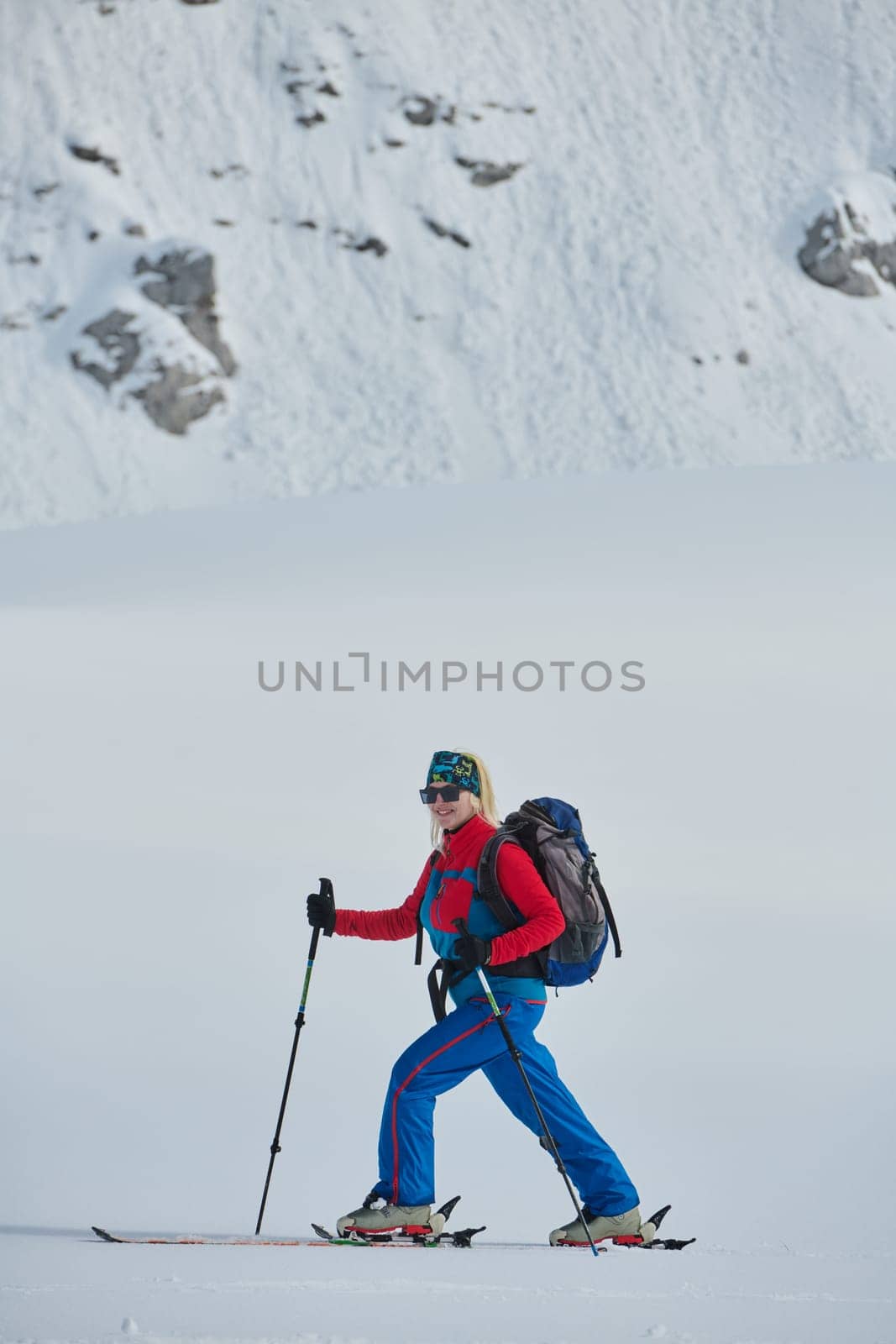 A Female Mountaineer Ascends the Alps with Backcountry Gear by dotshock