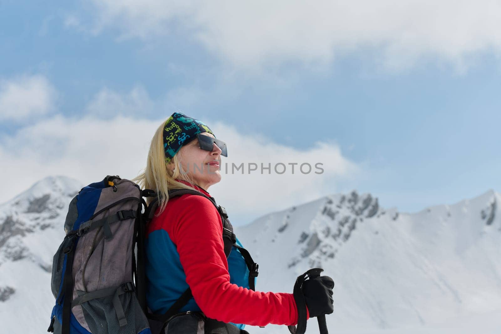 A determined skier scales a snow-capped peak in the Alps, carrying backcountry gear for an epic descent