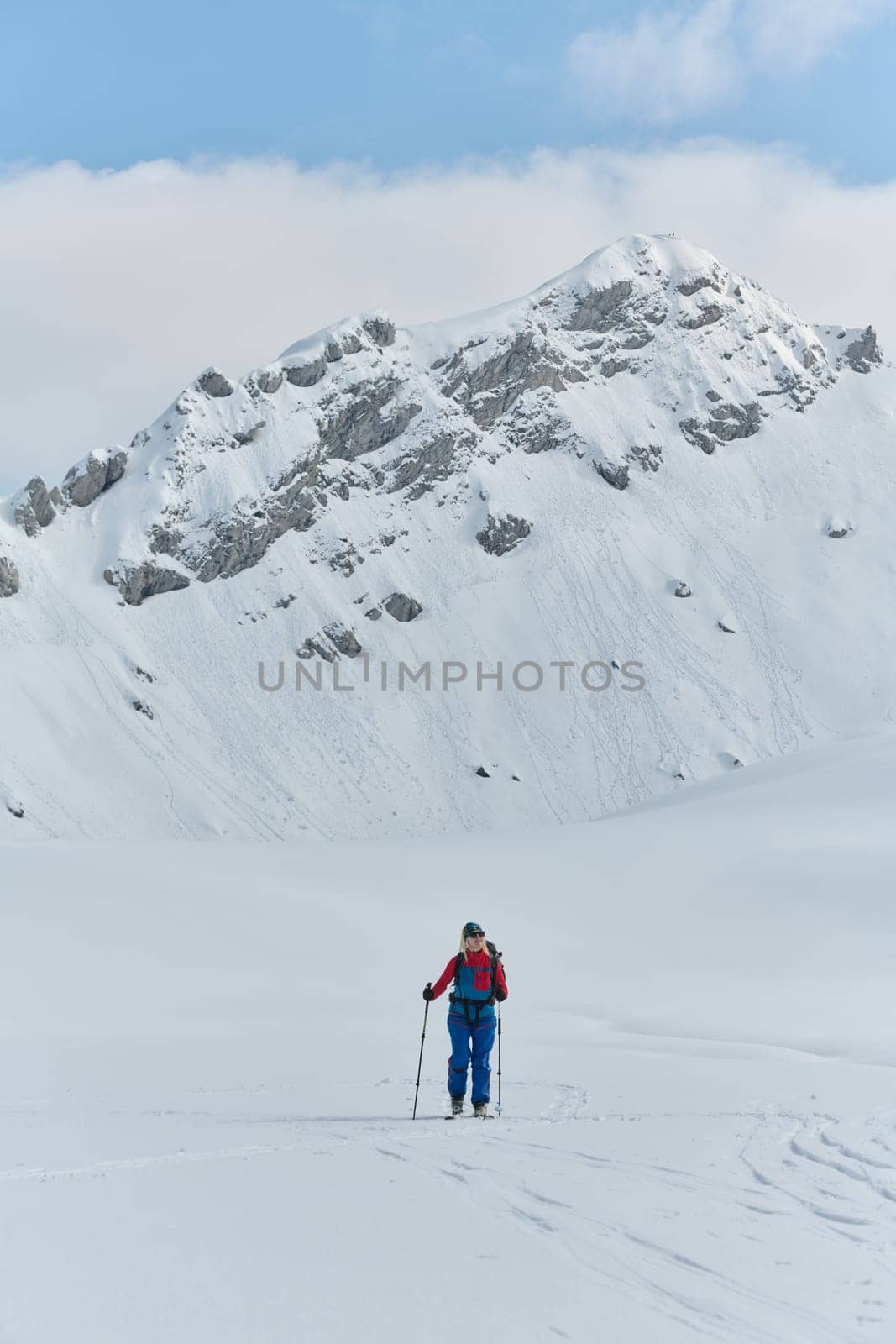 A Female Mountaineer Ascends the Alps with Backcountry Gear by dotshock