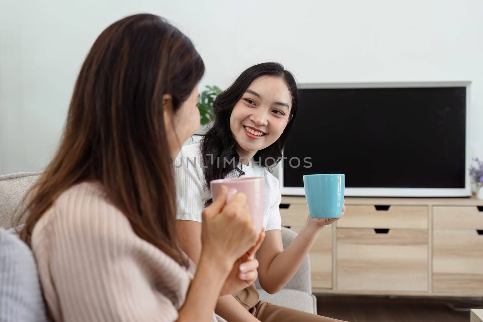 mature daughter and mother sitting together drinking hot drink in the morning. mature daughter and retired mother spend weekend together.