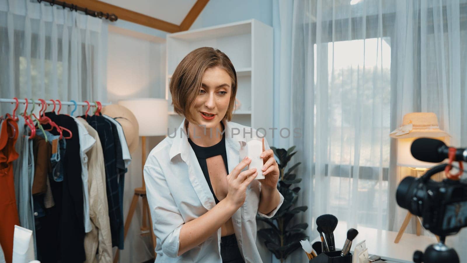 Woman influencer shoot live streaming vlog video review skincare for prim social media or blog. Happy young girl with cosmetics studio lighting for marketing recording session broadcasting online.