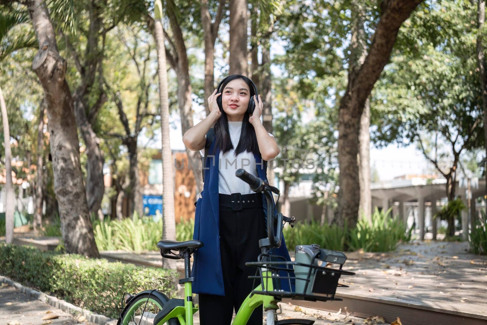 Asian businesswoman ride a bicycle in the city to work outside the city to reduce carbon emissions. Alternative transportation for green energy by wichayada