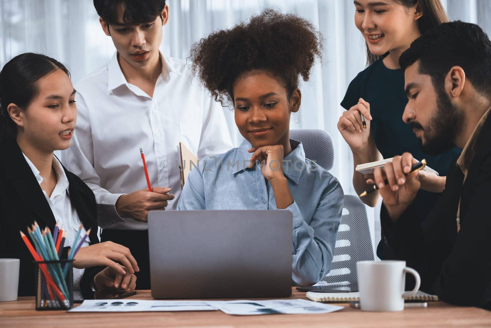 Happy diverse business people work together, discussing in corporate office. Professional and diversity teamwork discuss business plan on desk with laptop. Modern multicultural office worker. Concord