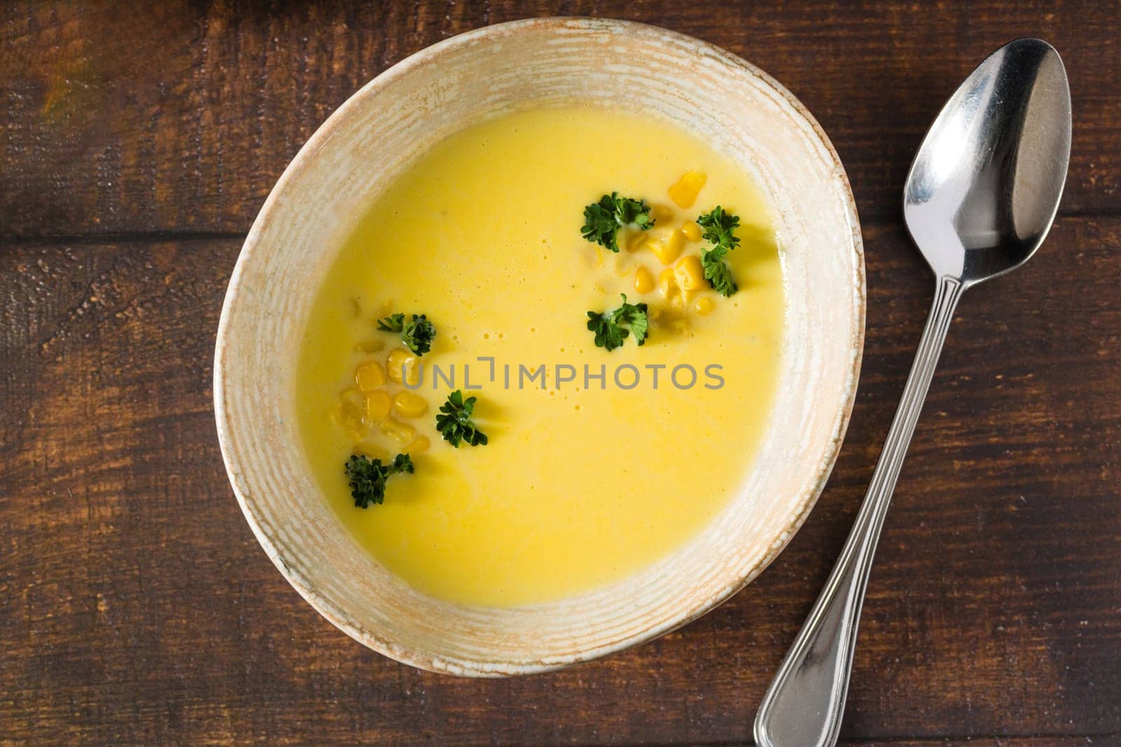 Top view of Italian corn soup on wooden table