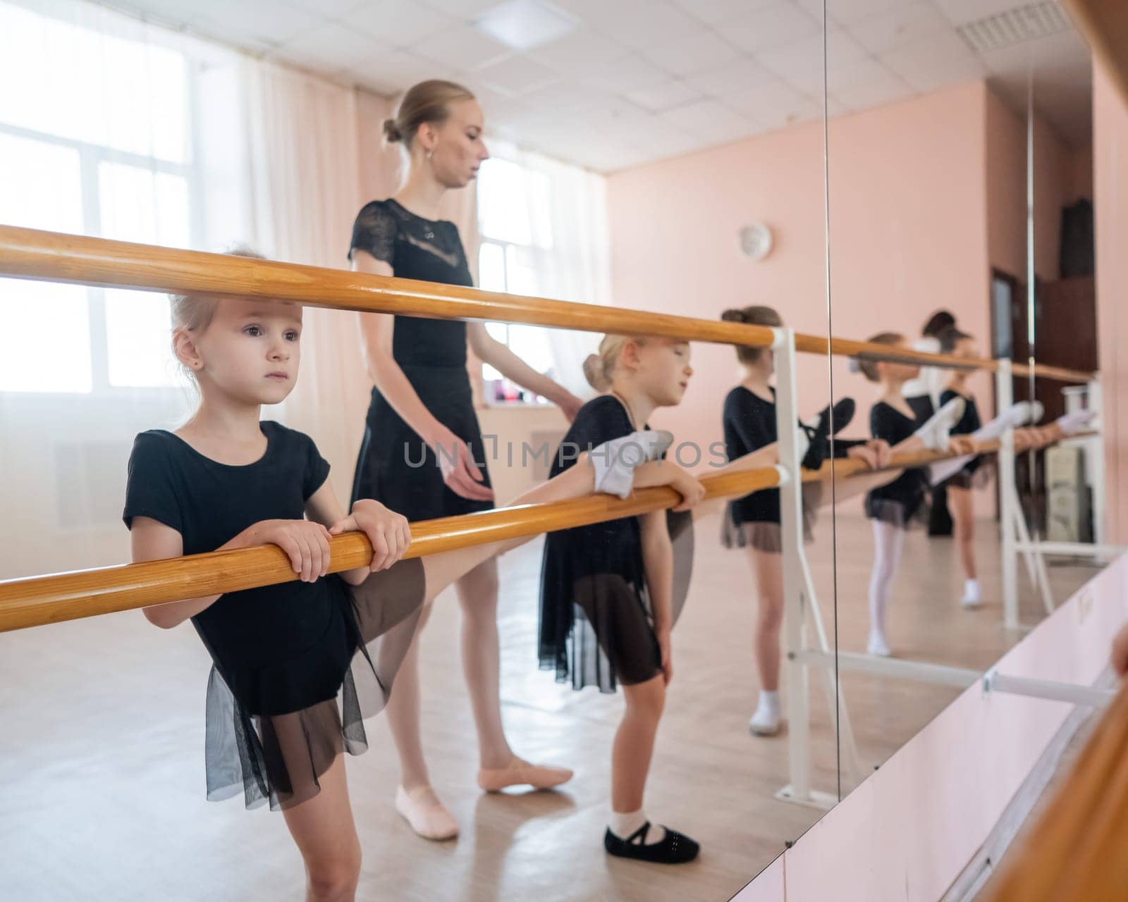 Little girls practice ballet at the barre