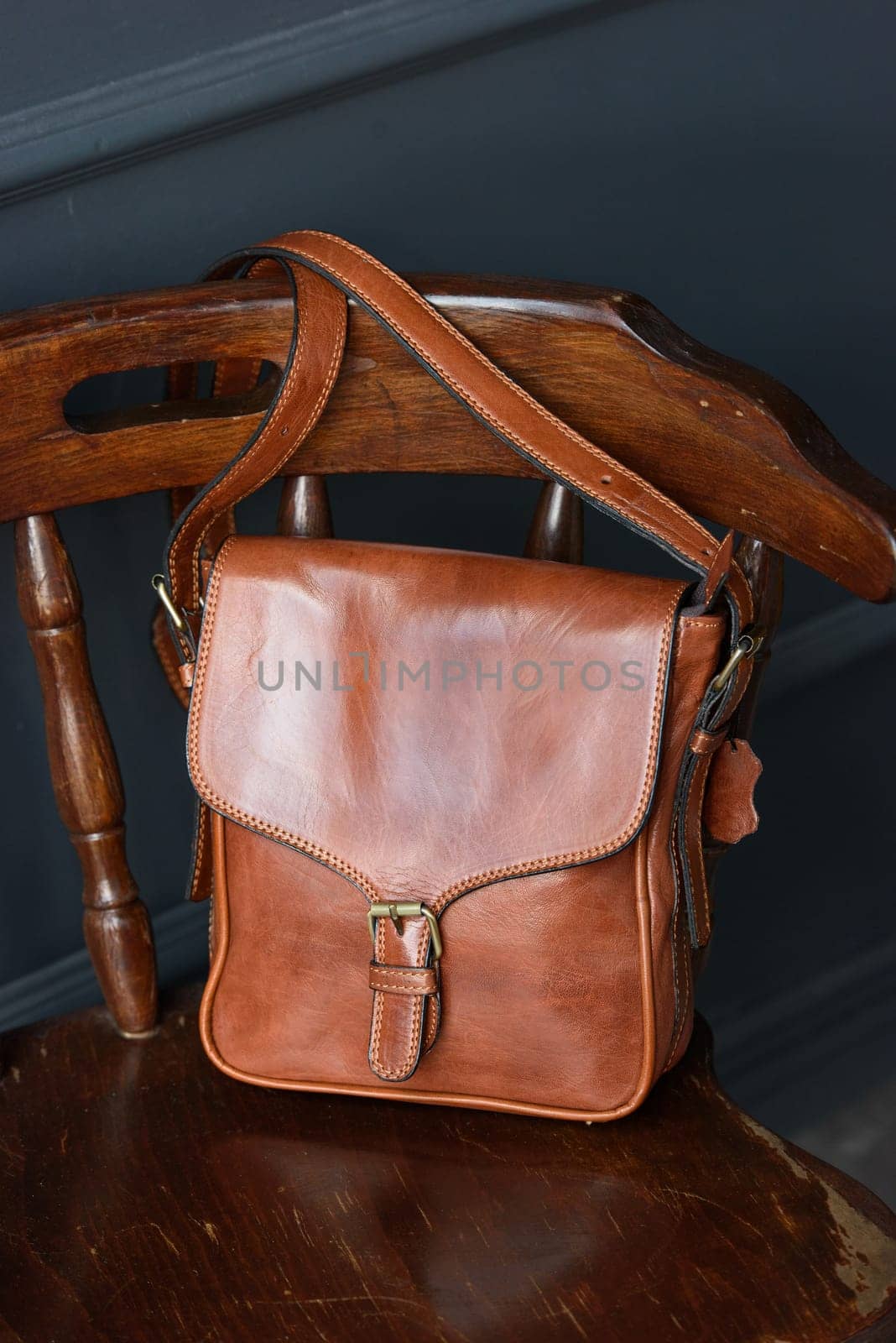 close-up photo of brown messanger leather bag on a chair