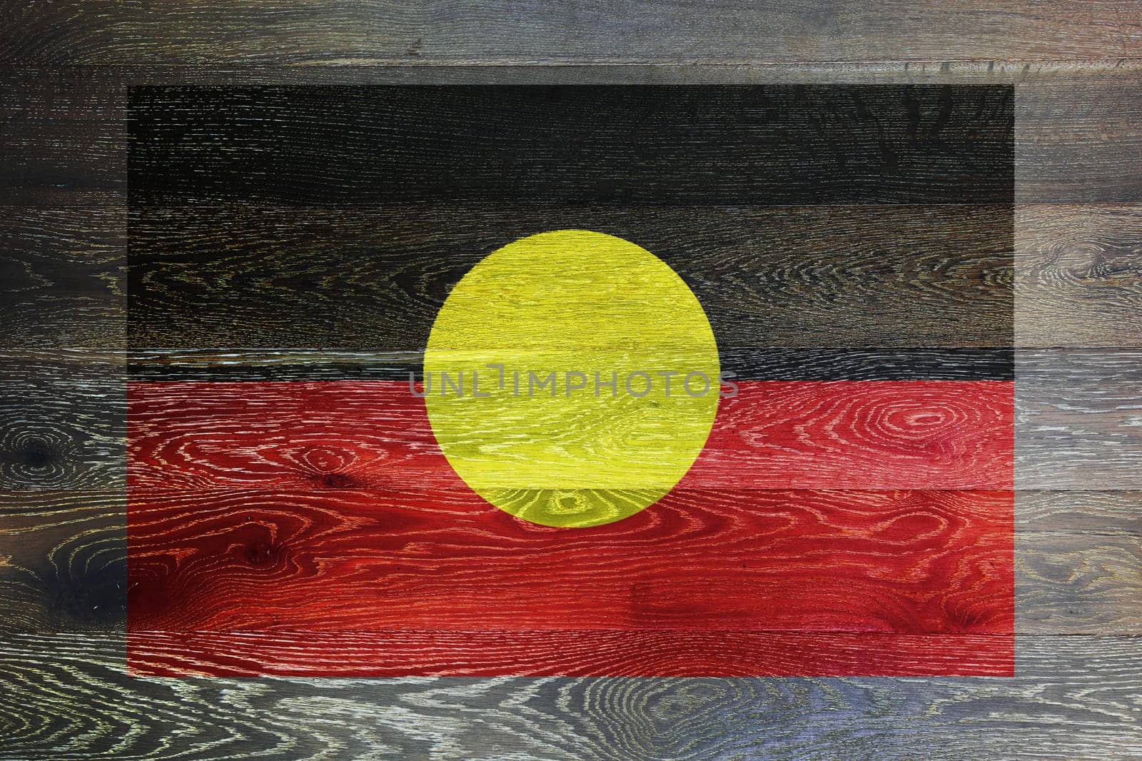 Australia aboriginal flag on rustic old wood surface background by VivacityImages