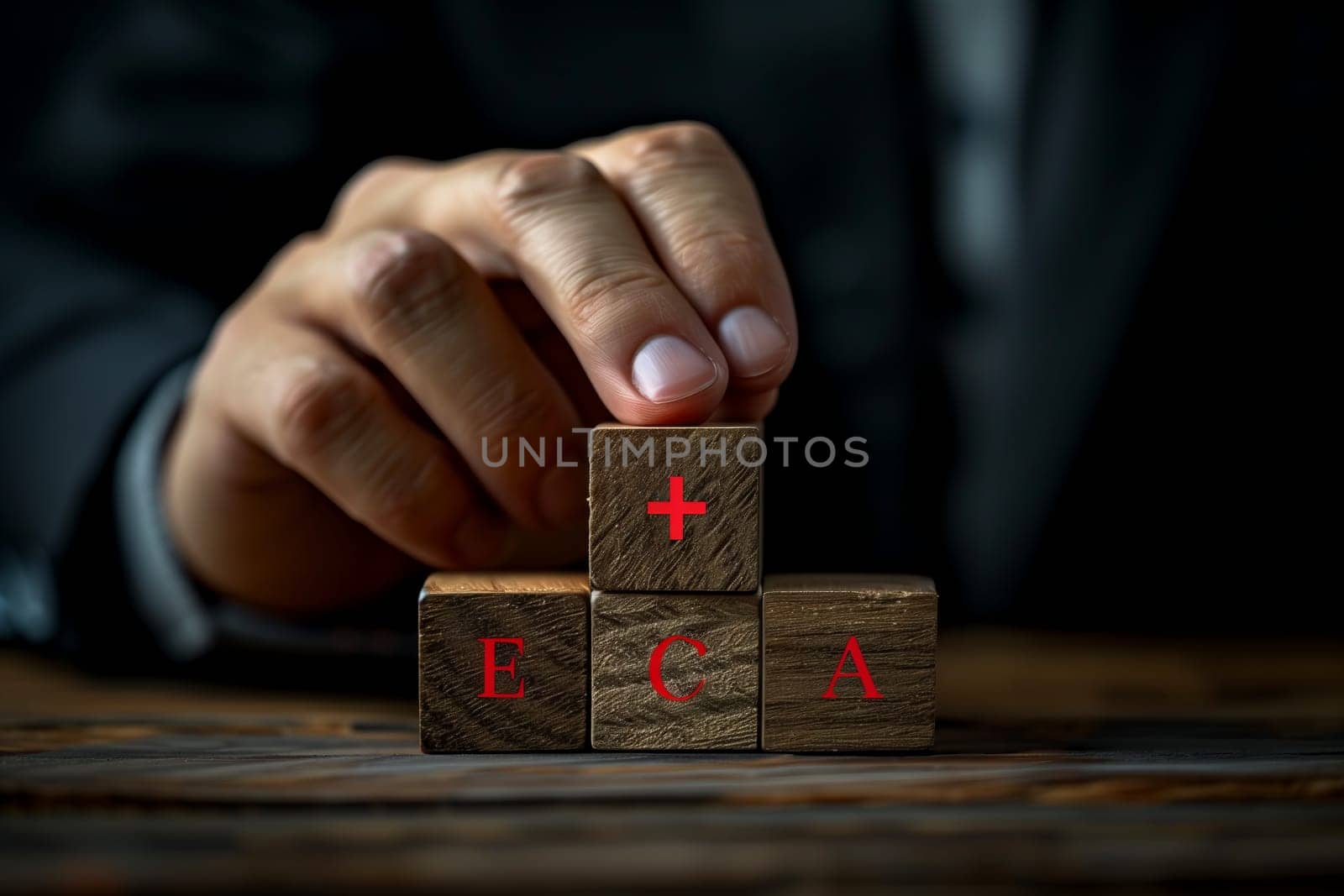 Using deft finger and thumb movements, the person skillfully stacks hardwood blocks in a game of indoor recreation. The wrist flicks with precision in the darkness