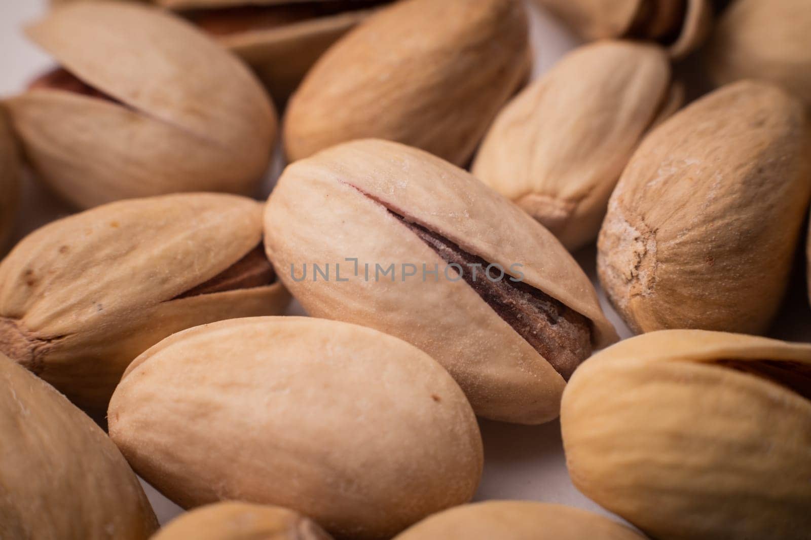 Many closed pistachios in macro close-up. Healthy food background with selective soft focus by yanik88