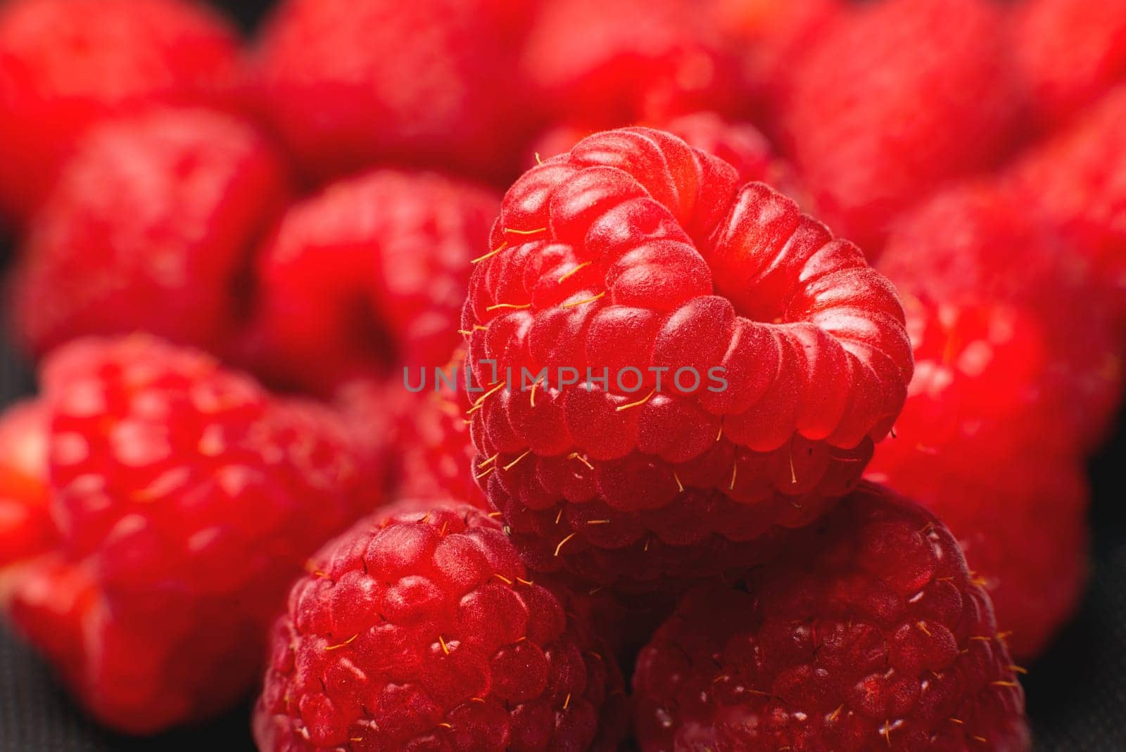 Close-up of fresh delicious raspberries in macro photography. Delicious berries vitamins and healthy food by yanik88