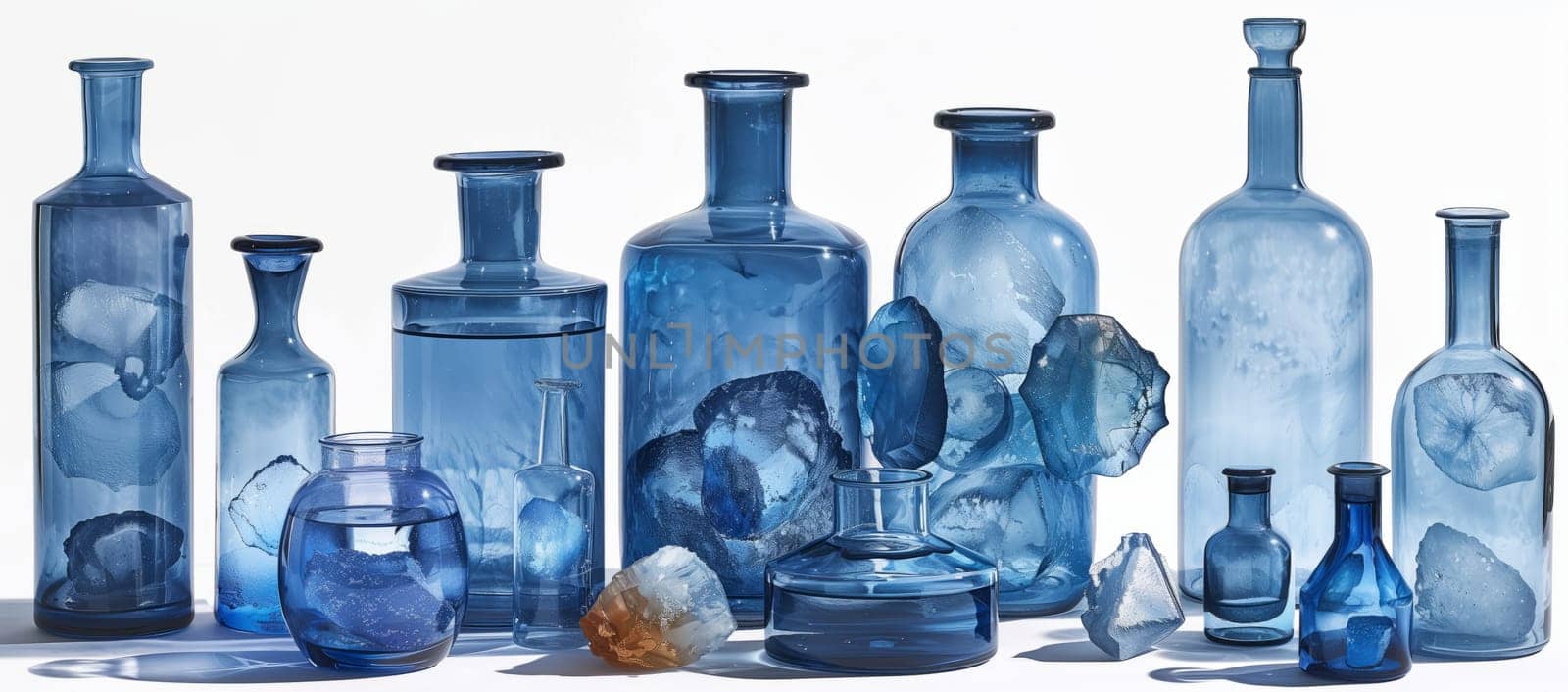 Group of electric blue glass bottles lined up on white background by richwolf