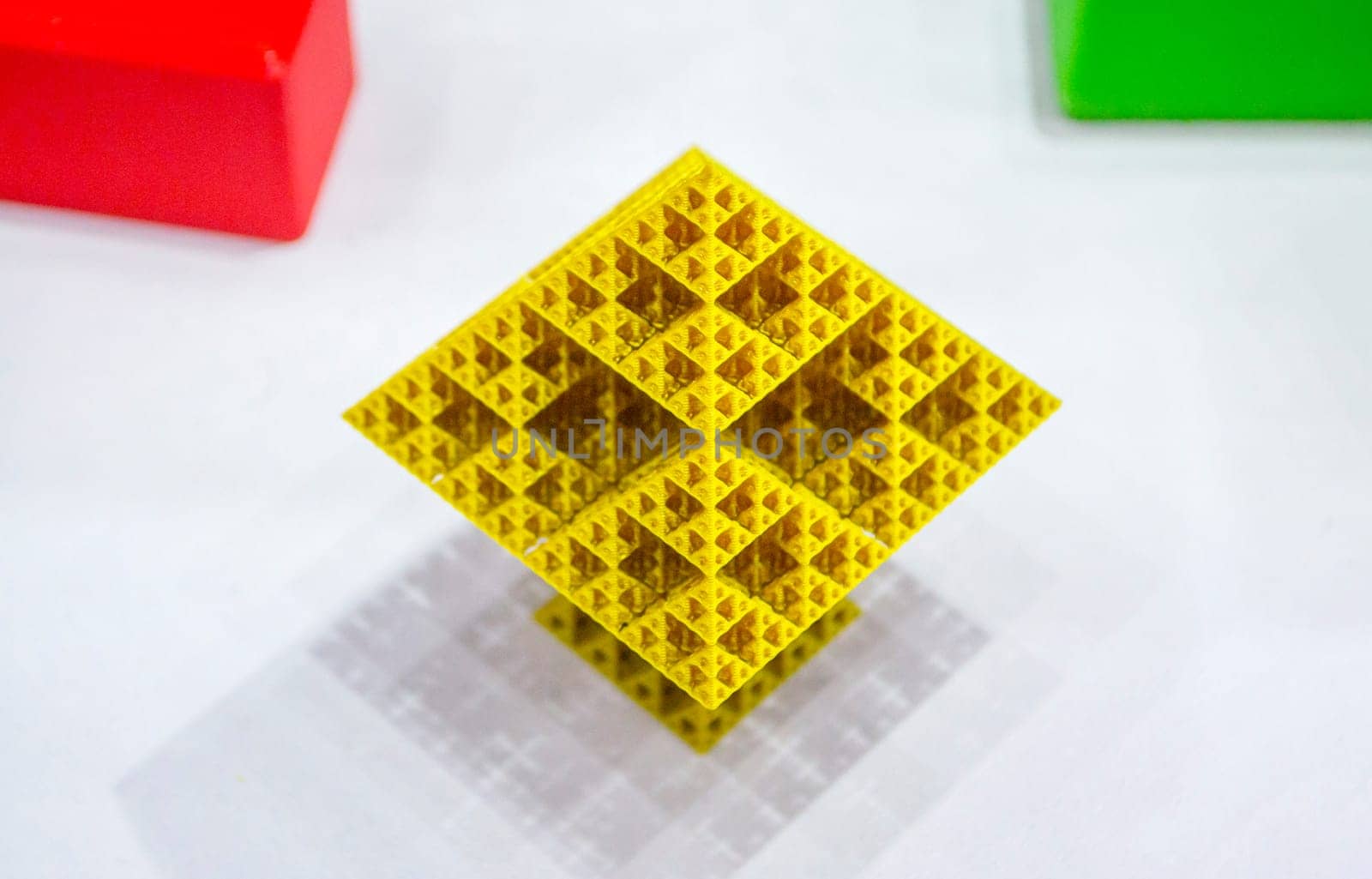 Abstract yellow object printed on 3D printer. Abstract geometric shaped object created by 3D printer. Detailed prototype printed on 3D printer close-up. New modern additive 3D printing technologies