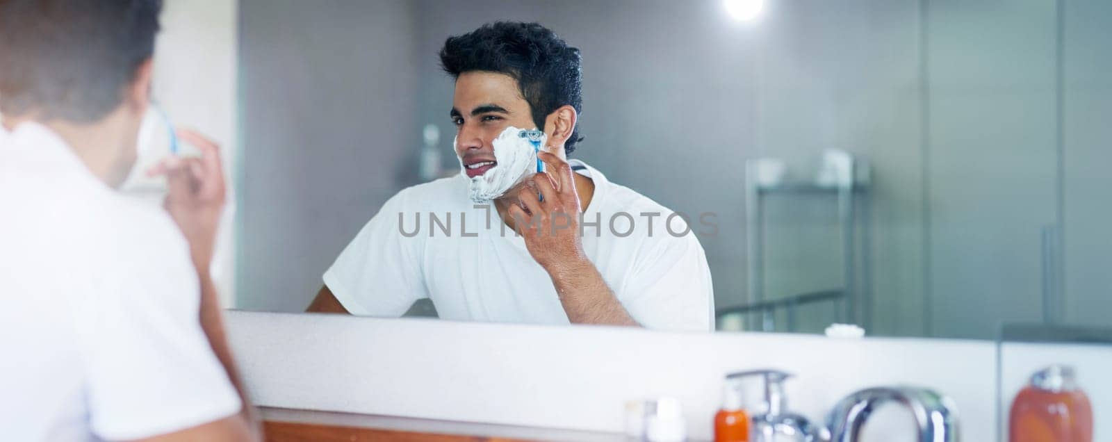 Shaving cream, mirror and man in bathroom for hygiene, grooming and washing face at home, house and apartment. Male person, gen z guy and reflection of student with foam, banner and skin care routine.