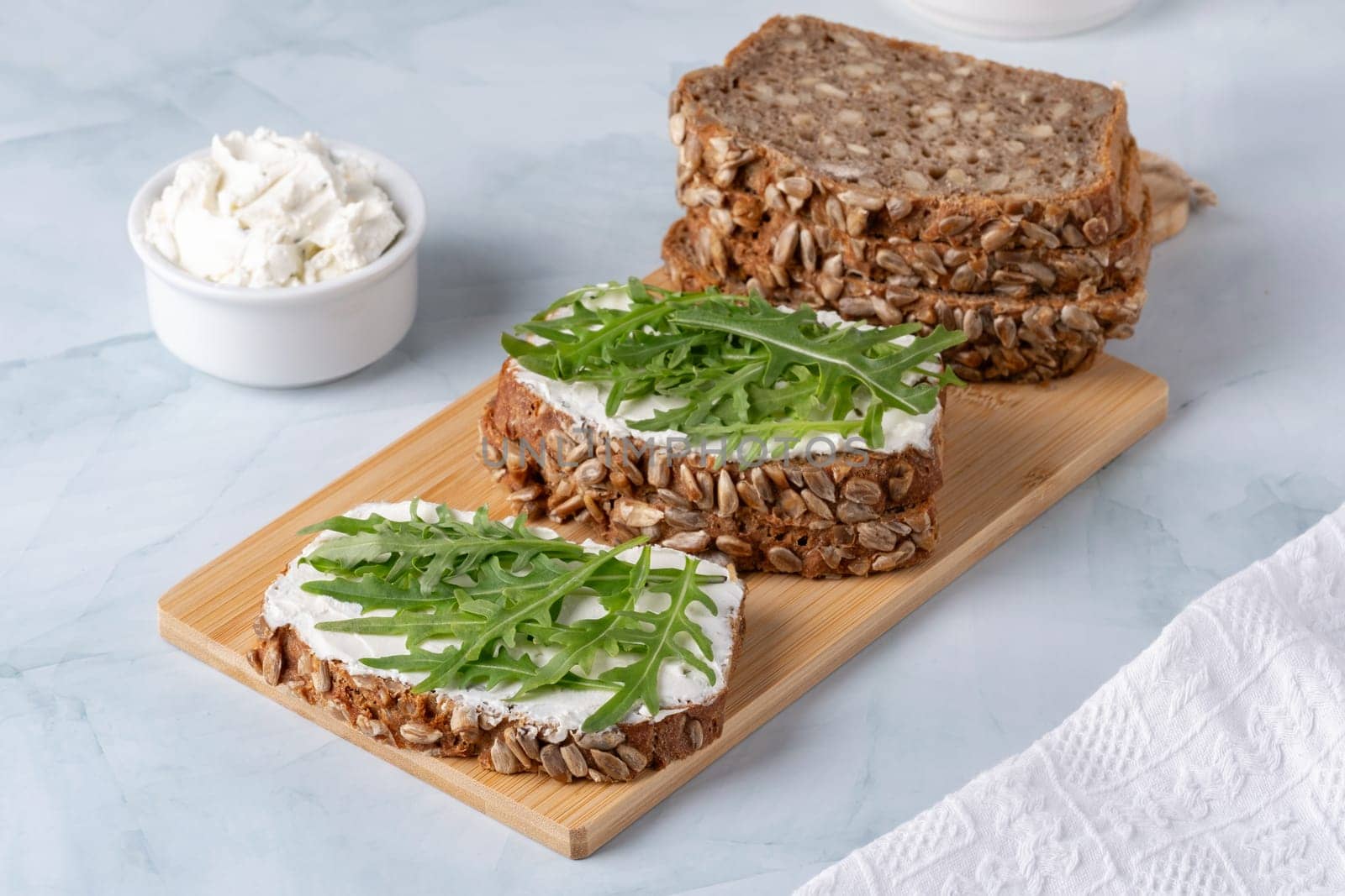 Sandwiches with curd cheese and arugula. Rye bread with seeds by NataliPopova