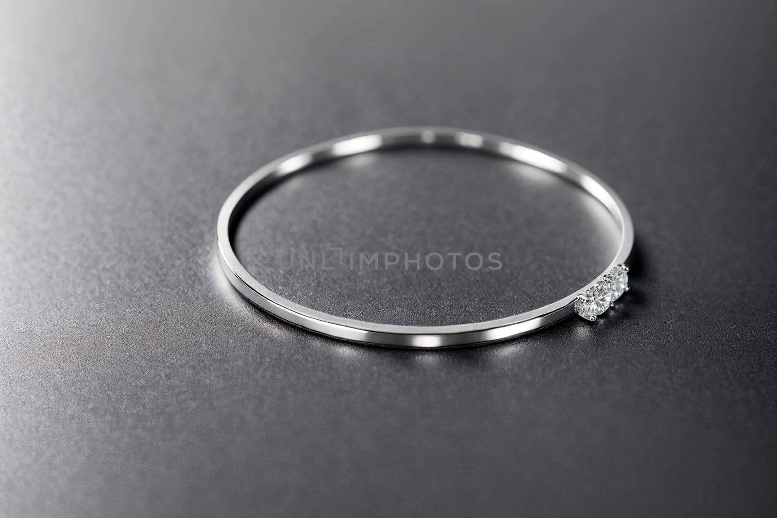 The image is a silver bangle with a small diamond in the center.
