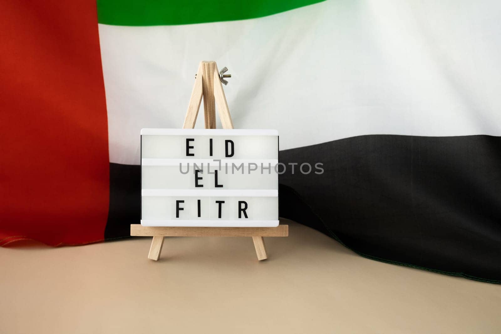 Message Lightbox EID EL FITR - Eid Mubarak - Happy Holidays text frame on United Arab Emirates waving flag made from silk material. Public holiday celebration background. The National Flag of UAE. Patriotism Commemoration Day Muslim Ramadan Blessed Holy Month concept