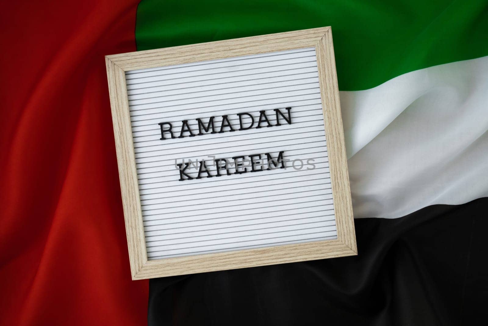 Congratulations with text RAMADAN KAREEM - happy holidays waving UAE flag on background concept. Greeting card advertisement. Commemoration Day Muslim Blessed holy month public holiday