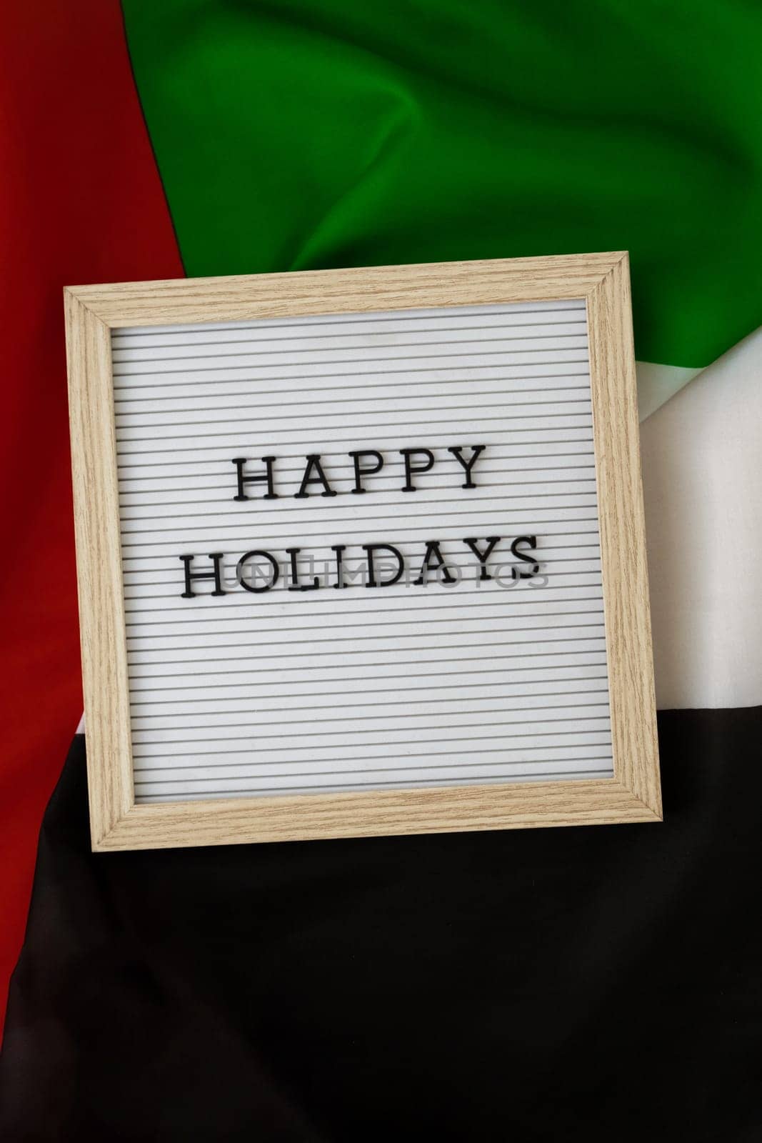 Message HAPPY HOLIDAYS on background waving flag of UAE. Independence Commemoration Day Muslim, Ramadan, Day of flag National holiday of United Arab Emirates. Arabian holidays. Dubai celebration