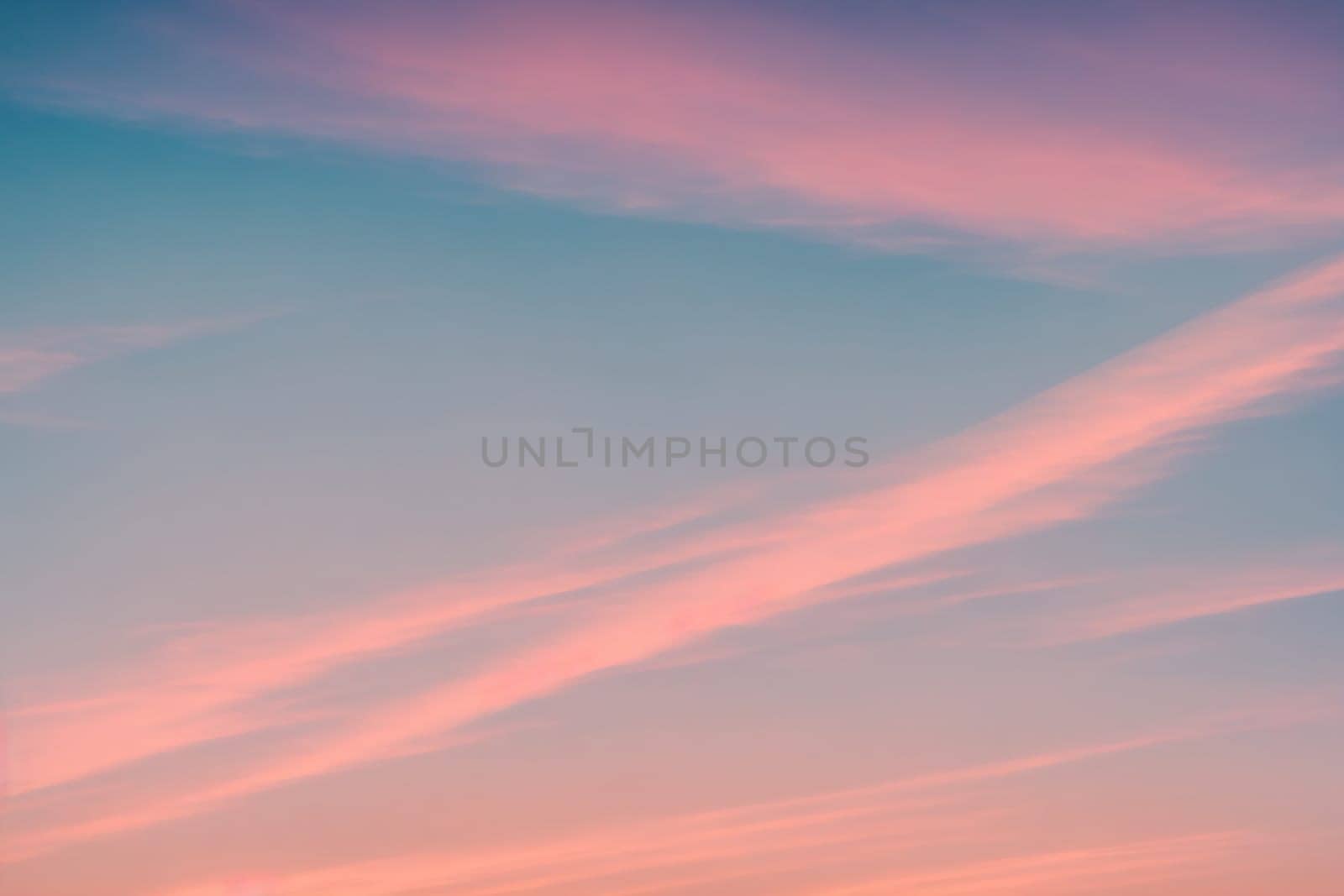 The image is a pink and purple sky with clouds and a sunset in the background.