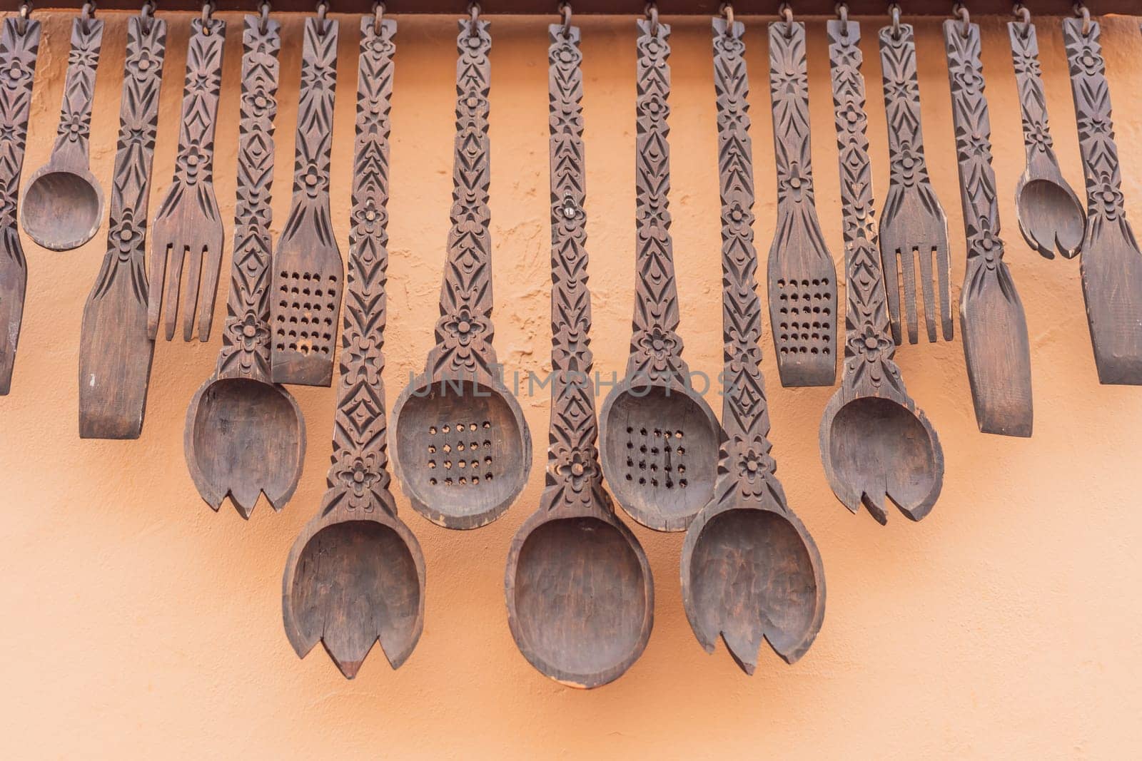 A collection of decorative large wooden spoons adds a touch of Mexican charm to an outdoor space, showcasing traditional craftsmanship and cultural motifs by galitskaya