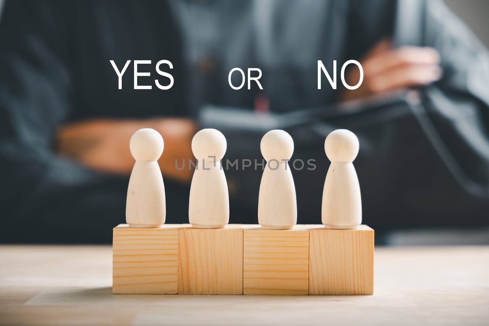 Peg dolls on wooden cube depict yes or no choices. Man's hand holds two options for decision-making. Red question mark reinforces the concept. Think With Yes Or No Choice. by Sorapop
