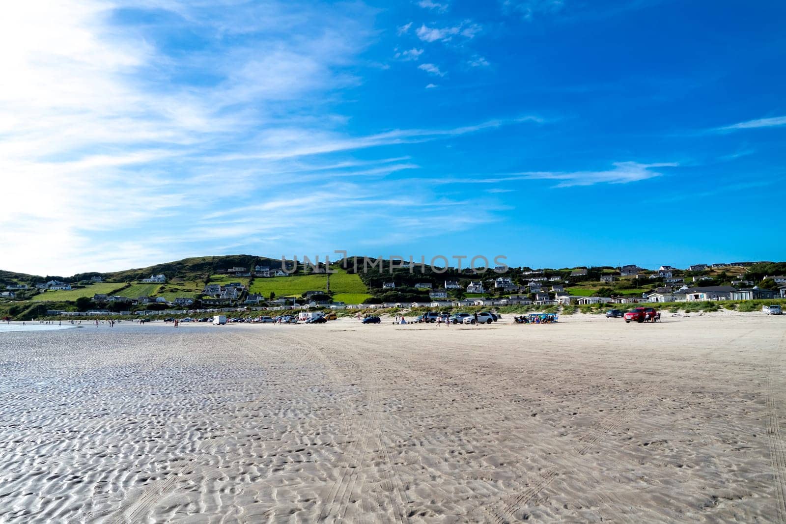 DOWNINGS, IRELAND - JULY 31 2022: Holiday makers enjoying the beach.