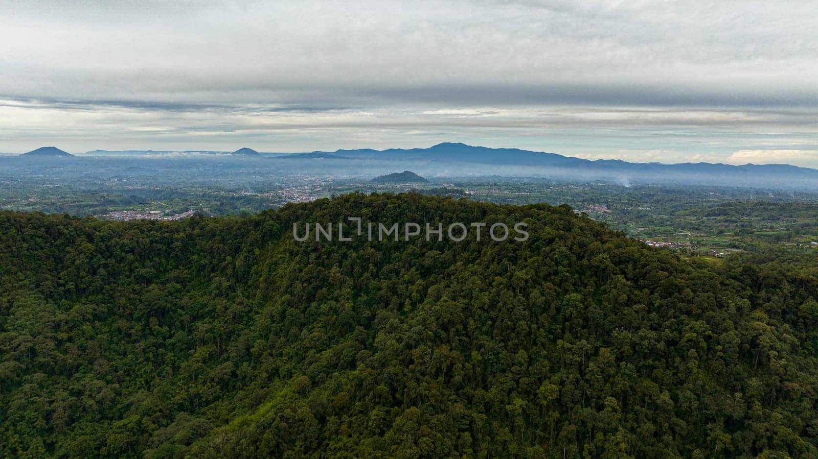 Aerial view of Berastagi city among mountains and farmland in a mountain valley. Sumatra. Indonesia.