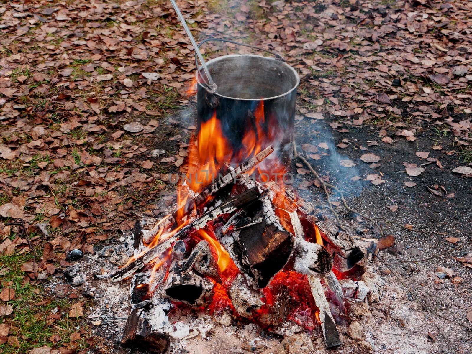 cauldron with food near the fire. Touristic metal bowler pot. Cooking at the campsite, picnic, outdoor recreation.