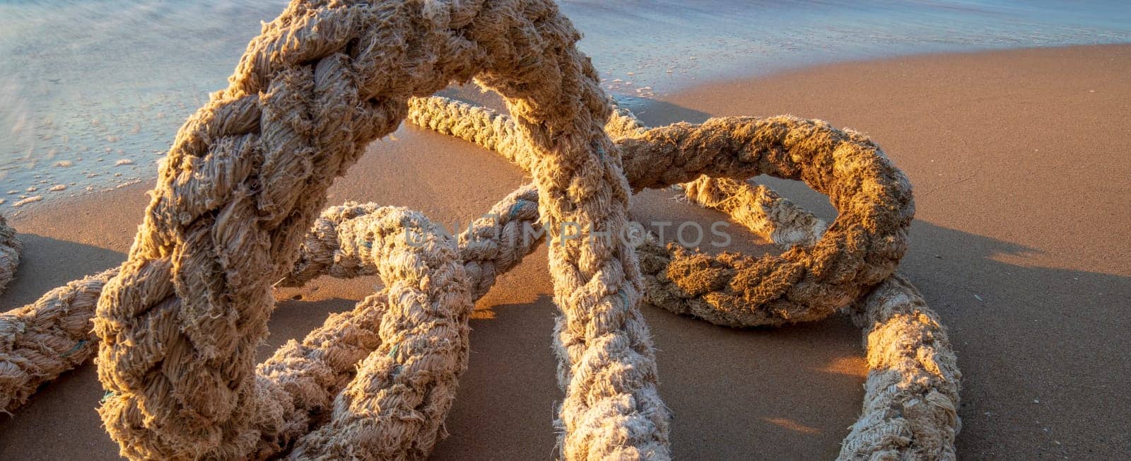 Big old boat rope on the beach. Close up