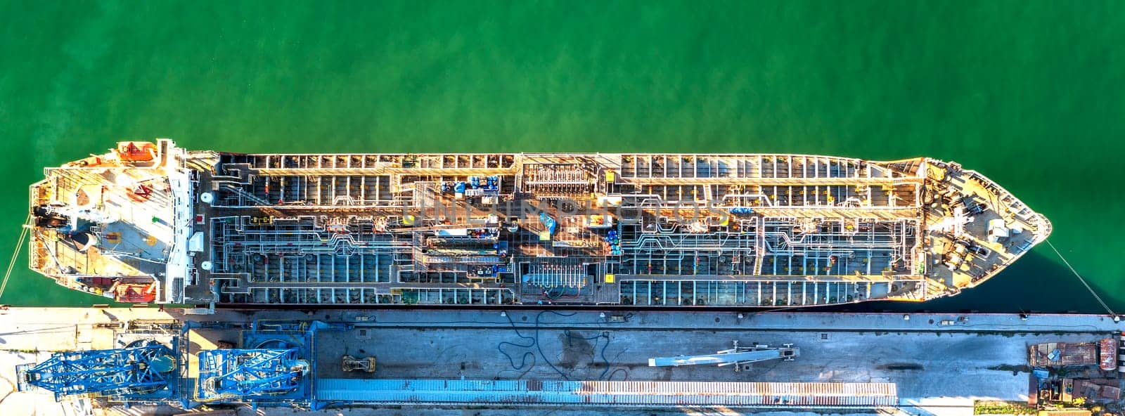 A chemical tanker of the city port. Aerial top view from a drone. Concept export ship