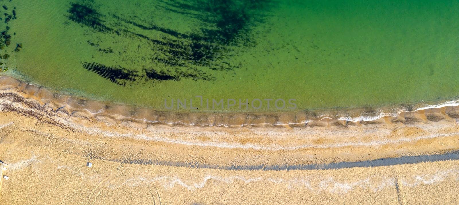 Aerial top view from drone to the coastline. Calm sea and sand