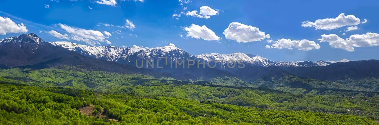 panoramic view from a drone of the mountain with snow peaks and green hills. by EdVal