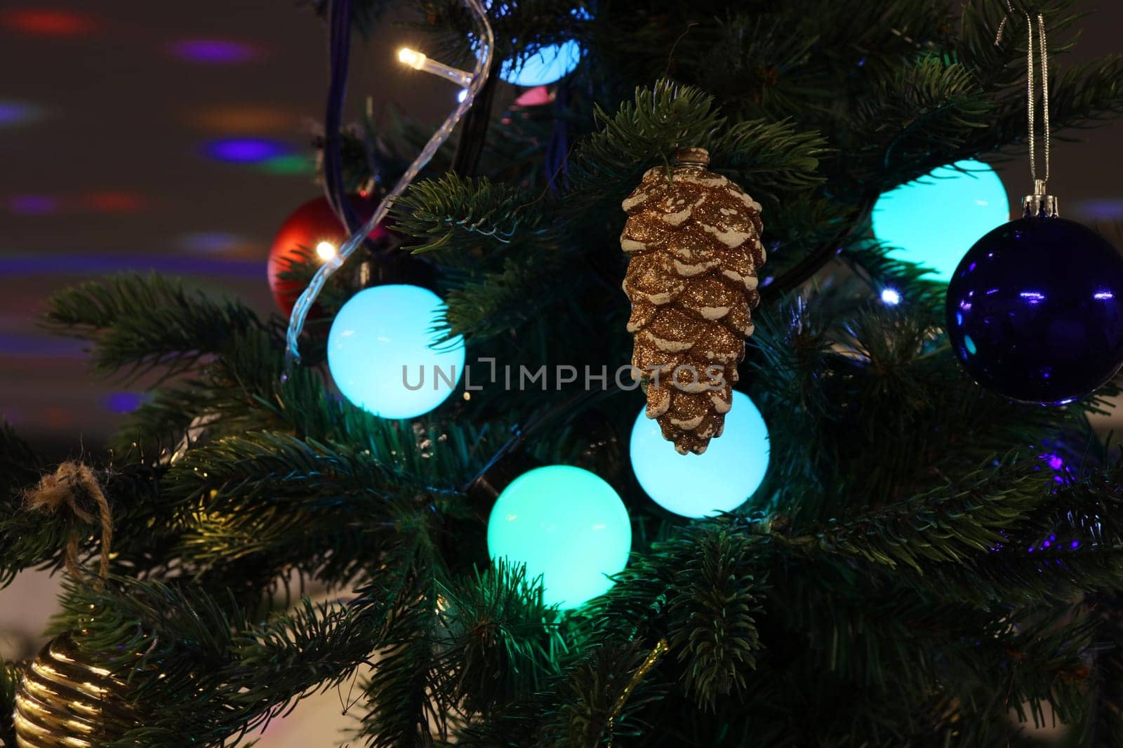 Brown Christmas toy in the shape of a pine cone close-up on a Christmas tree. by gelog67