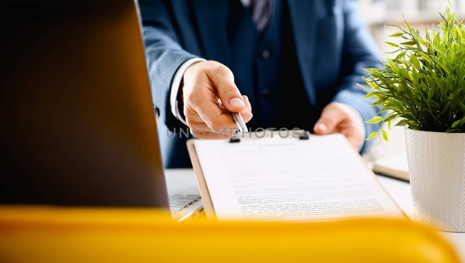 Male arm in suit offer contract form on clipboard pad and silver pen to sign closeup. Strike a bargain for profit white collar motivation union decision corporate sale insurance agent concept